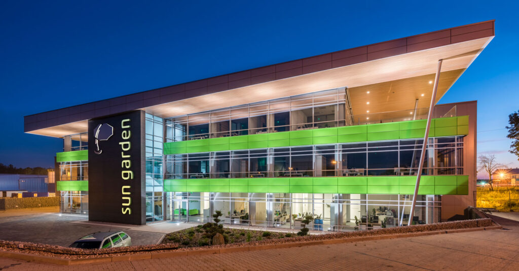 elewacja frontowa nocą - hala magazynowa z budynkiem biurowym, dla Sun Garden Poland, Malanów