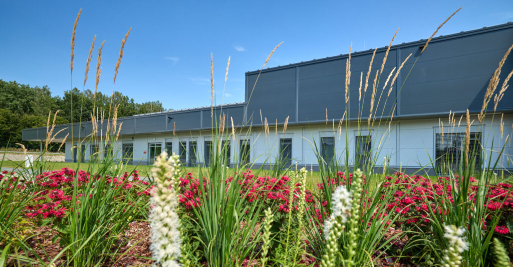 rabata z kwiatami przed częścią biurową obiektu - hala o powierzchni 6.000 m2, dla Herkules Wire, Jastrowo, woj. wielkopolskie