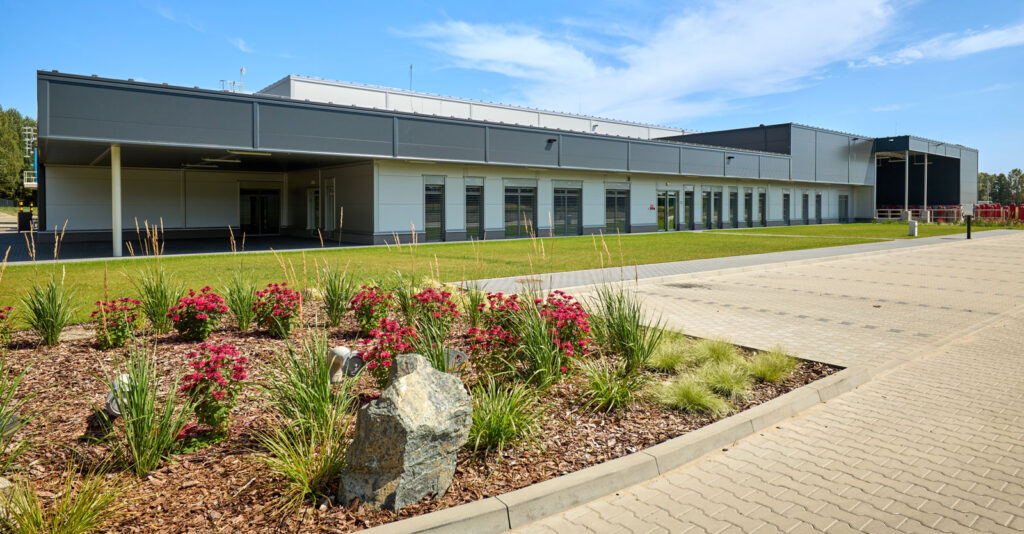 ozdobna roślinność przed biurowcem - zakład produkcyjno-magazynowy, dla Herkules Wire, projekt i budowa w Jastrowiu, w woj. wielkopolskim, przez CoBouw Polska z siedzibą w Łodzi