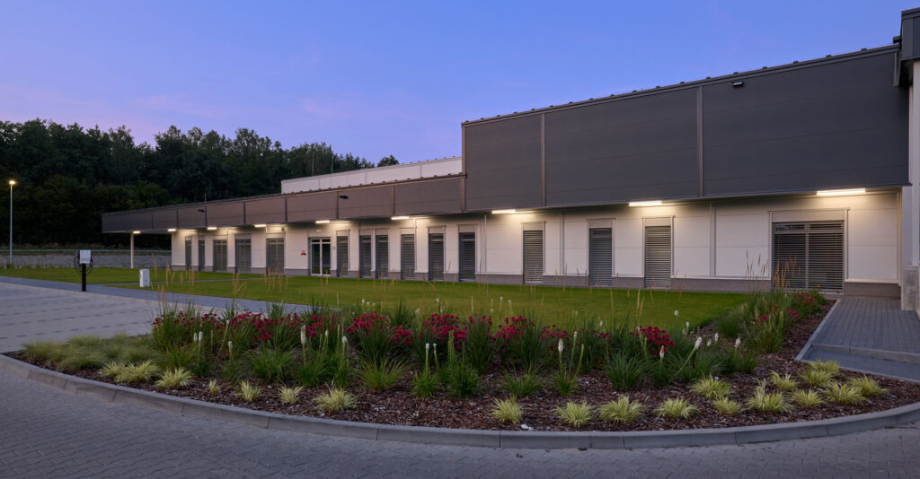 oświetlona część socjalno-biurowa, zdjęcie wieczorne - hala dla firmy Herkules Wire, w Jastrowiu