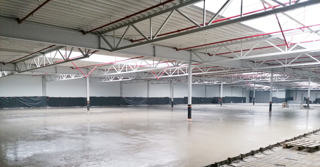 układanie posadzki w hali - rozbudowa kompleksu hal, dla Sun Garden Polska, przez CoBouw Polska, w woj. wielkopolskim