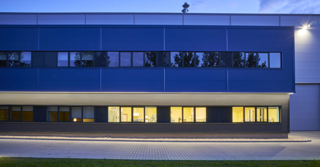 elewacja frontowa budynku, widok nocny - zakład produkcji tworzyw sztucznych, dla włoskiej firmy Sirmax, budowa pod klucz CoBouw Polska, Kutno, woj. łódzkie