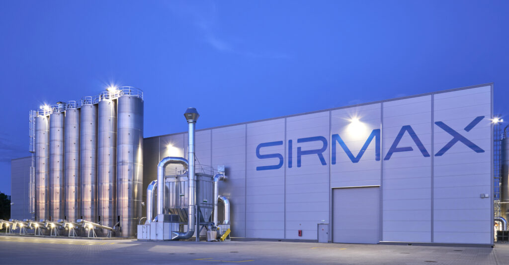 zdjęcie nocne hali Sirmax - zakład produkcji tworzyw sztucznych, z budynkiem socjalno-biurowym, generalny wykonawca CoBouw Polska, woj. łódzkie