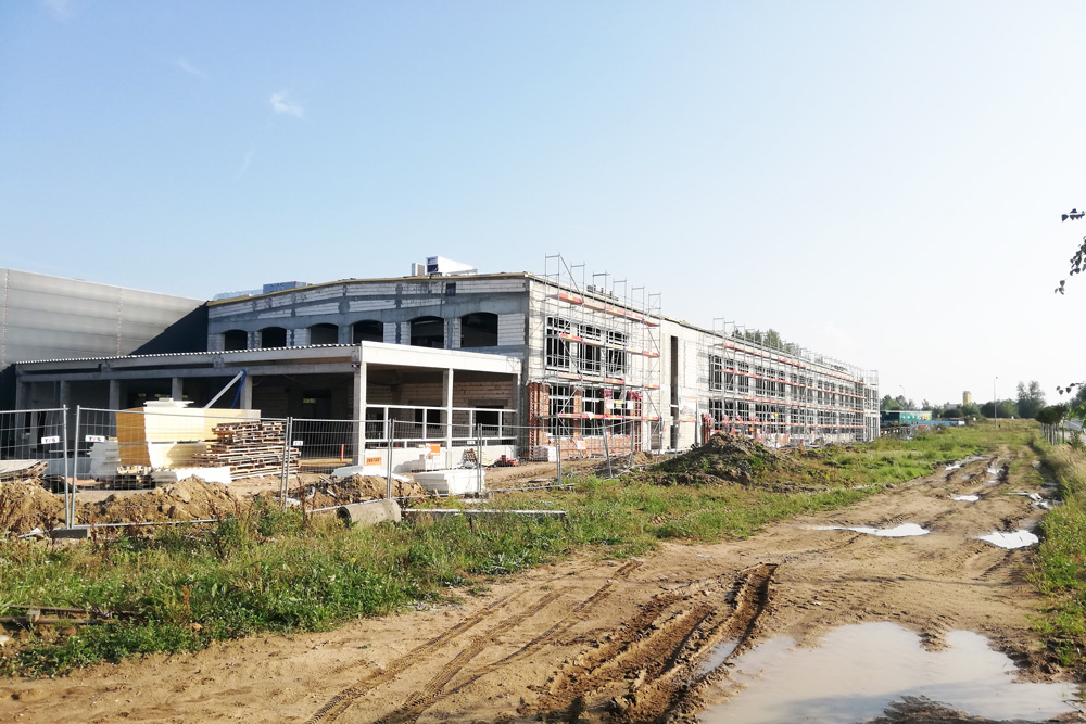 widok na budowę hali producyjno-magazynowej - zakład produkcyjno-magazynowy z częścią socjalno-biurową, dla Linea, Koszlain, woj. zachodniopomorskie